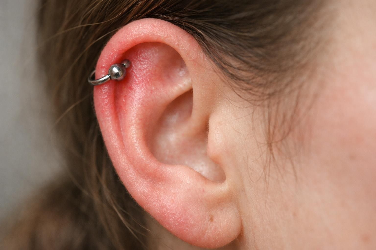 découvrez les causes possibles de la douleur un an après un piercing hélix et les solutions pour soulager et prendre soin de votre oreille.